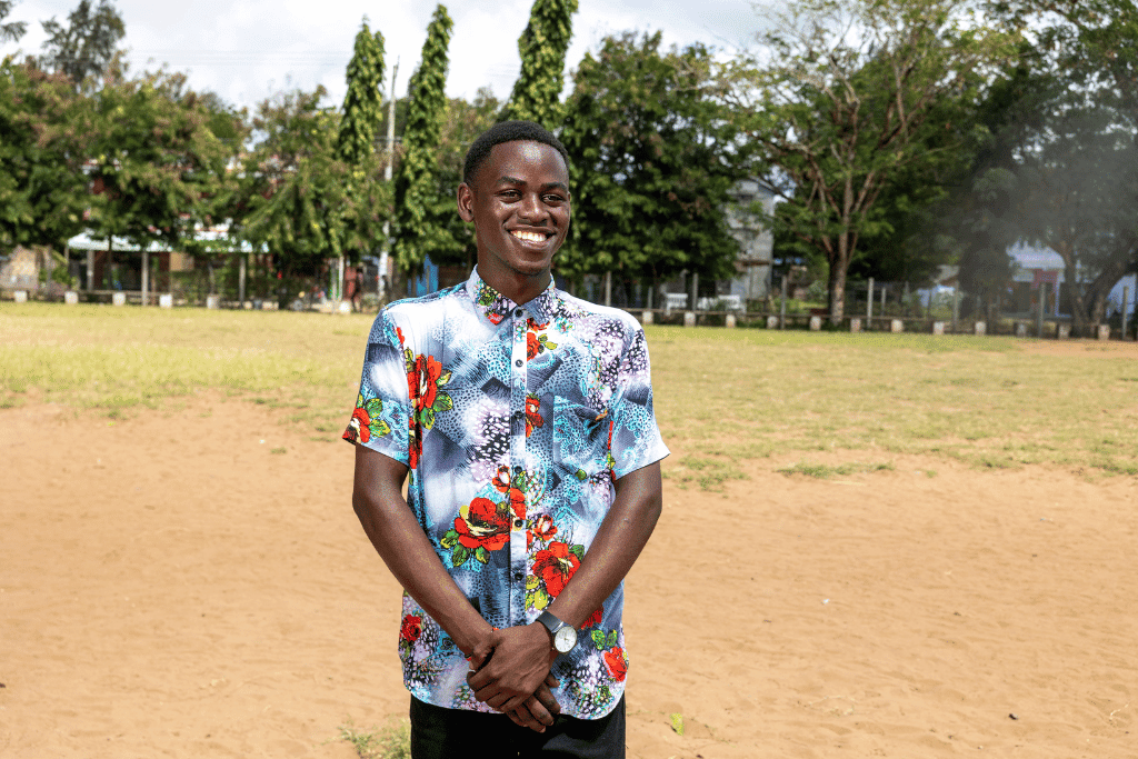Festus is a mental health ambassador in Kenya. He is pictured here in a colourful shirt, smiling.