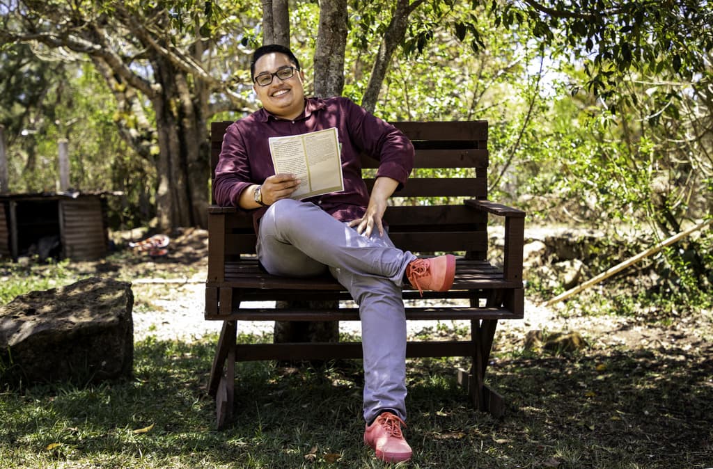 Aldo, a Compassion graduate from Honduras holds letters from his sponsor