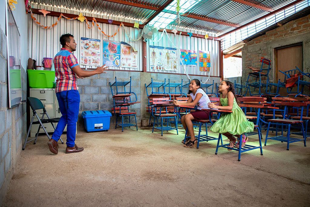 Two students and their teacher in a classroom in Nicaragua.