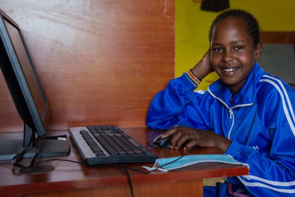 Dorothy sits at a computer in Kenya