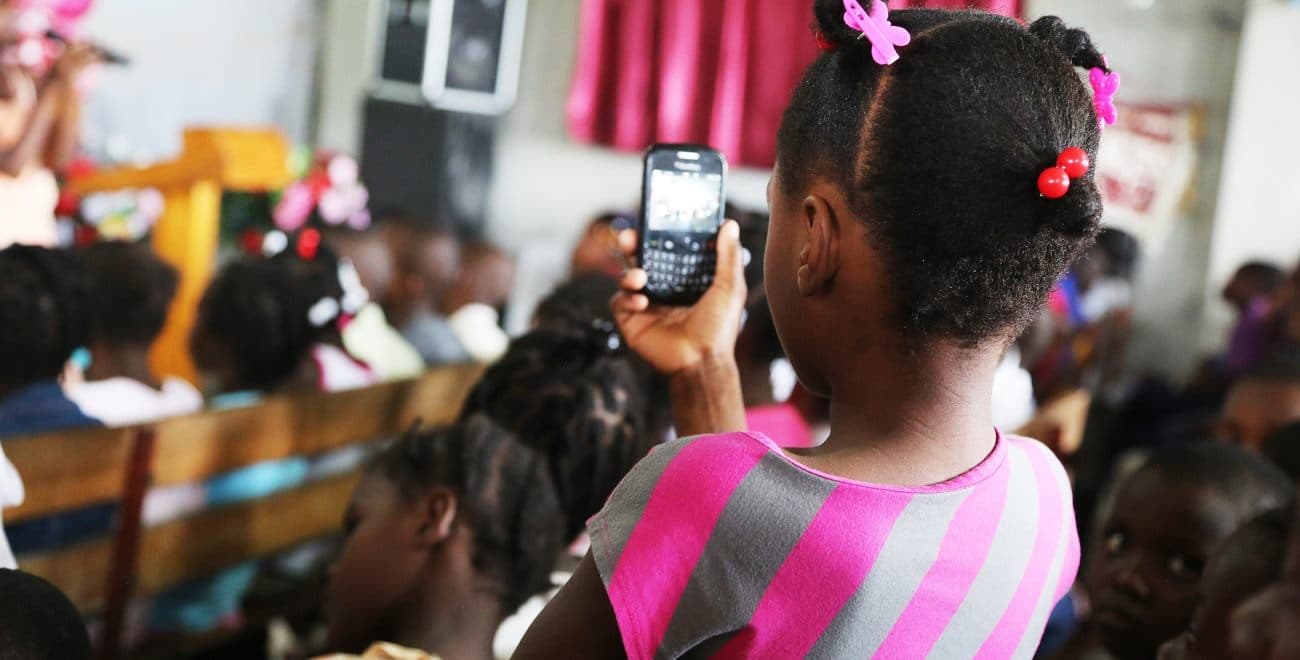 Haitian girl holding mobile phone