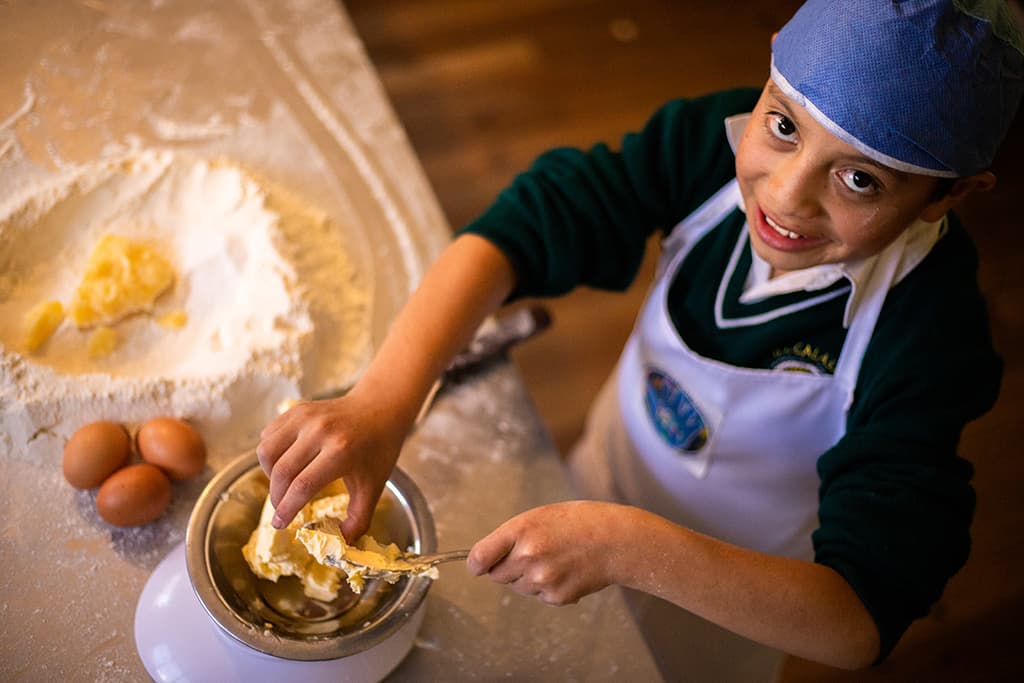 A boy from Ecuador weighing out butter
