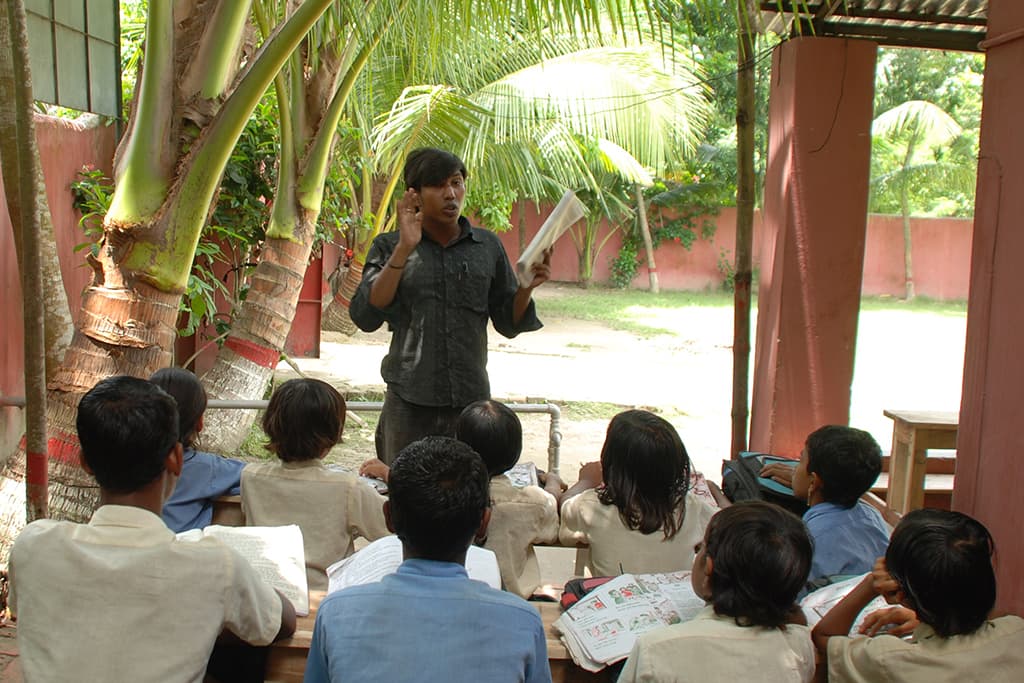 Xavier teaching a group of children outside