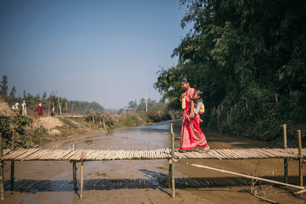 Kohima and baby Joy walk on a bridge