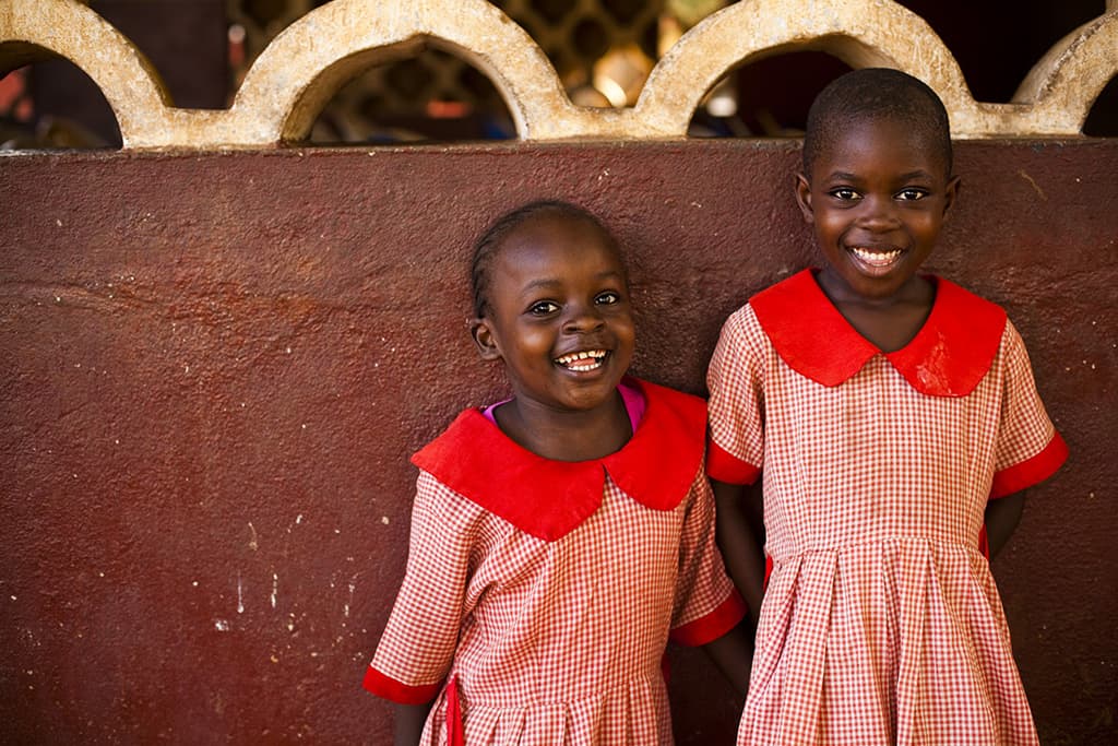 kenya girls in red dresses infront of wall