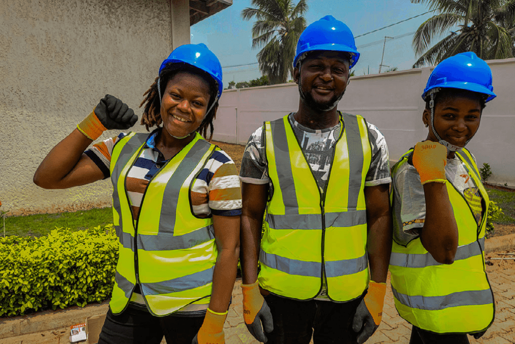 Winner stands with her colleagues in high visibility jackets and helmets.