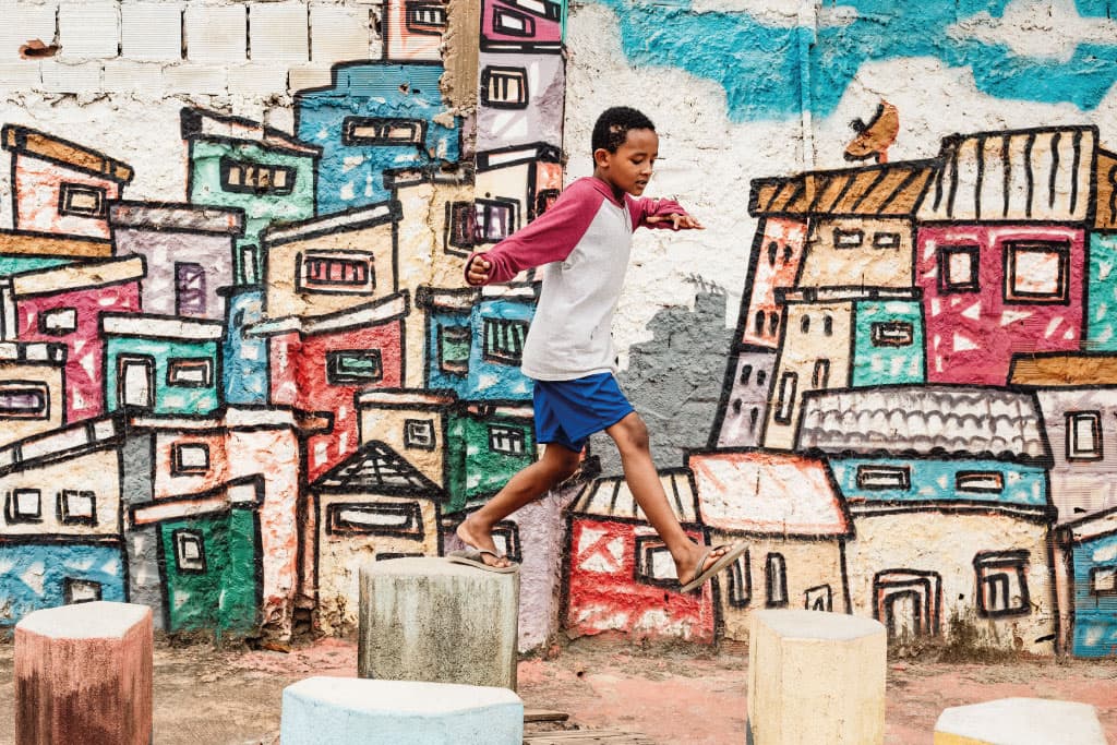 Lucas from Brazil plays in front of graffiti