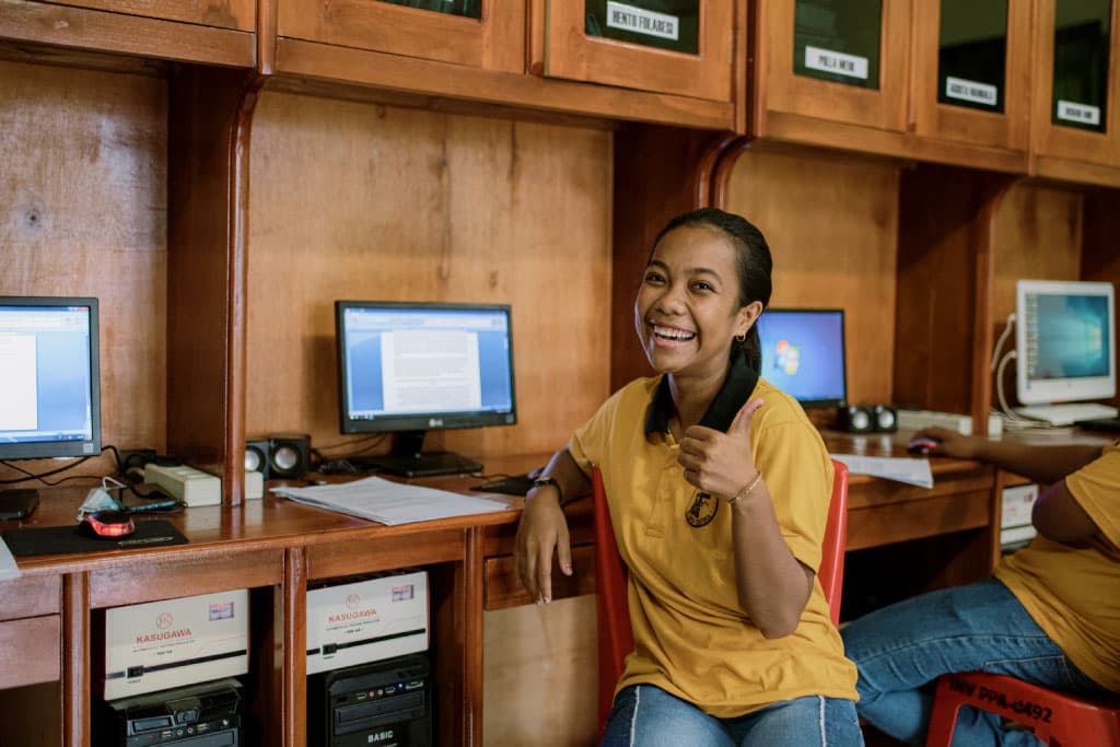 Inggrid smiles sitting in Compassion's computer lab