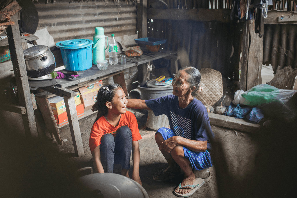 Tivani laughs as her grandmother strokes her hair.