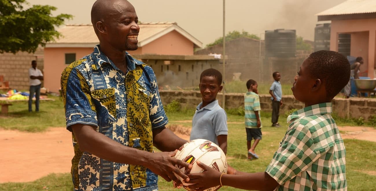 Henry handing a ball to a child1