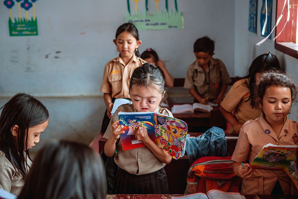 Karunia reading in a classroom in Indonesia