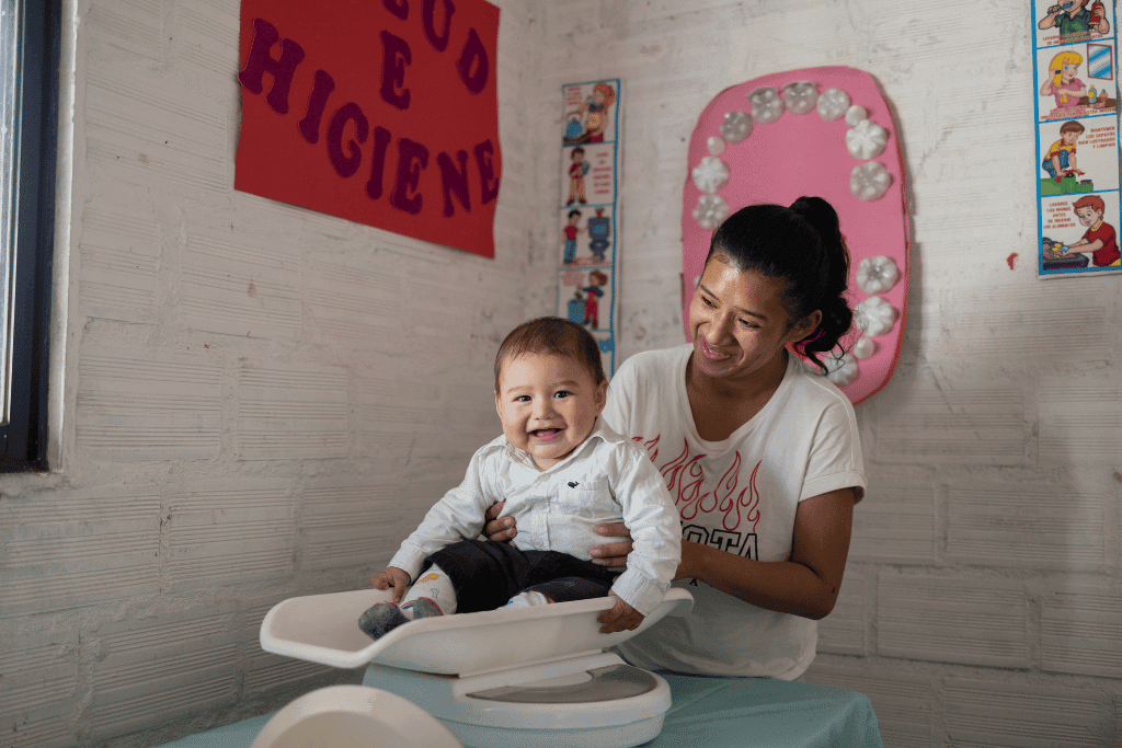 Baby Liam is smiling at the camera as mum, Luz Clarita holds him