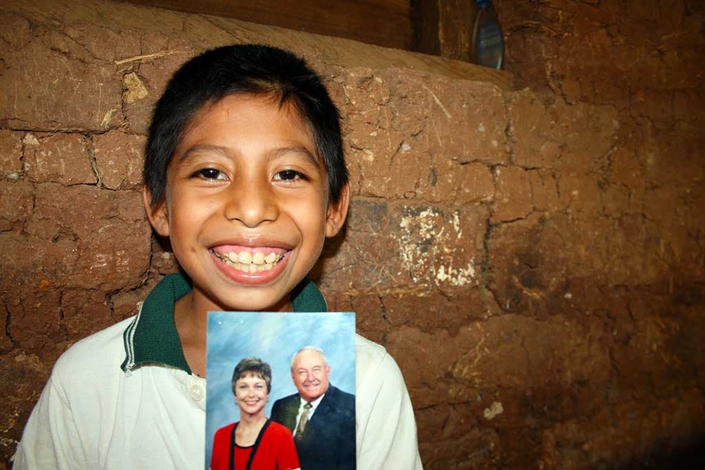 Joel holding a photo of his sponsors