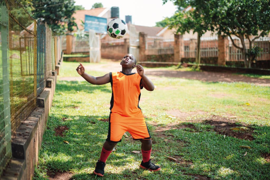 Rian from Uganda heads a ball
