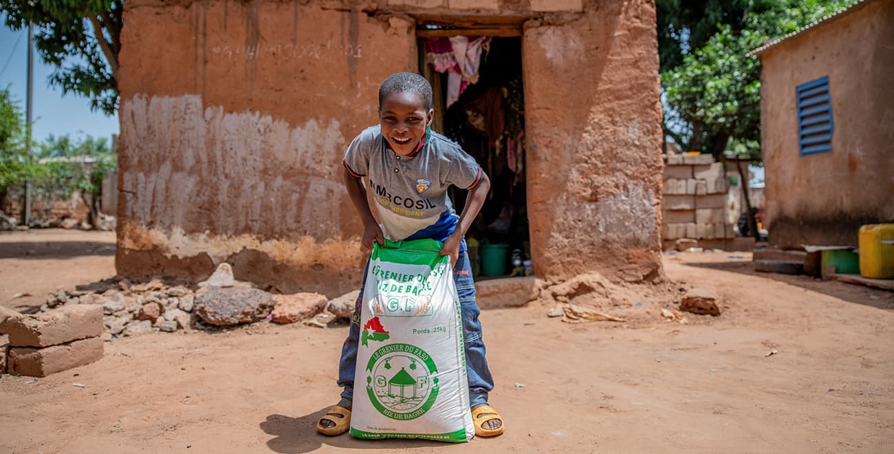 A boy holding a food parcel in Burkina Faso