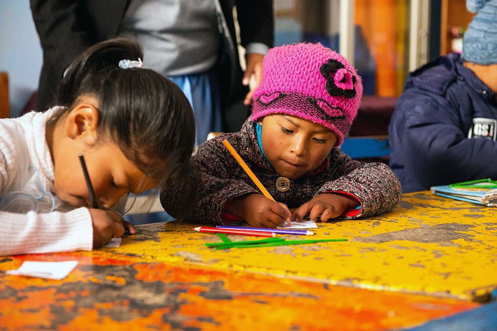 Children practice writing in a classroom in Bolivia