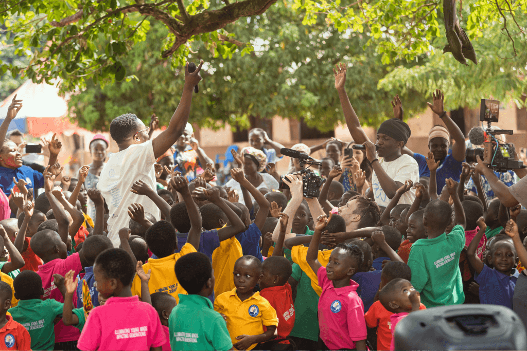 Faithchild and DC3 rapping with children at a Compassion project in Ghana