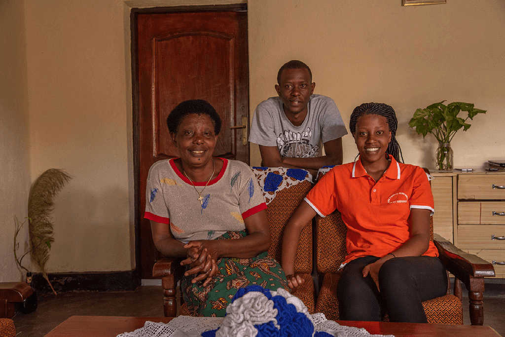 Yvette sits and smiles with her family.