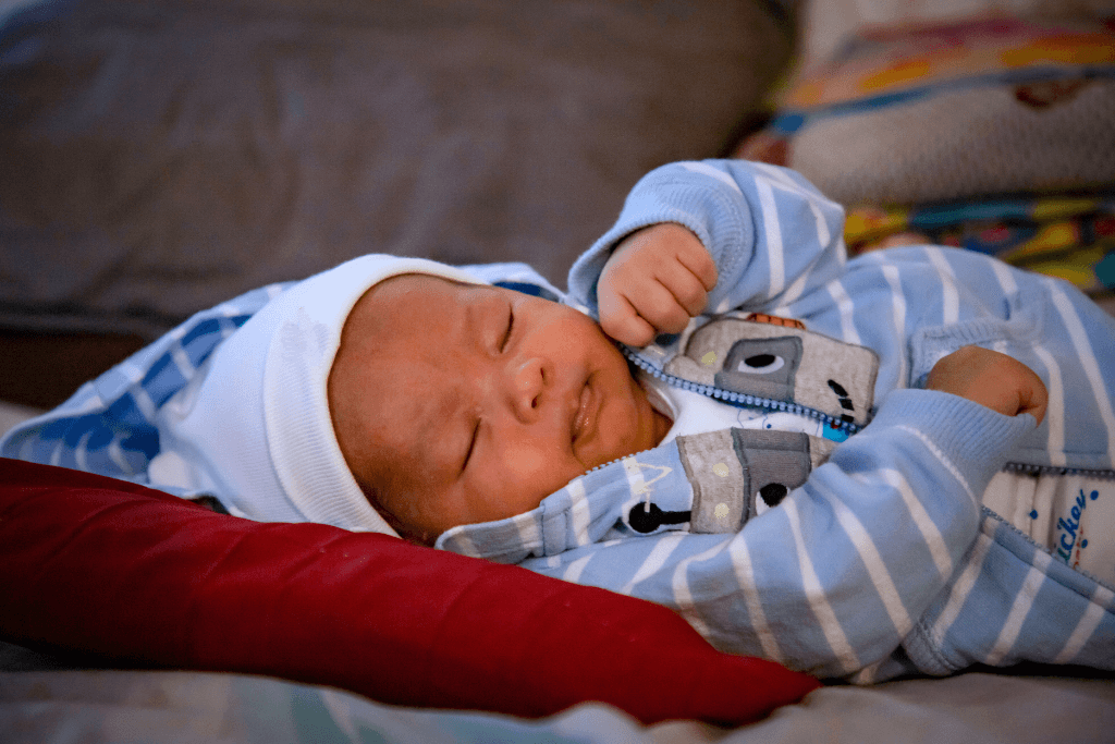 Baby Santiago sleeping in a blue and white outfit