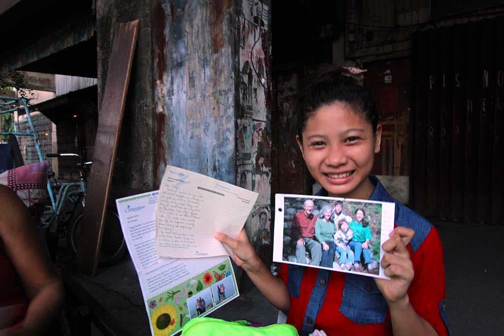 Sponsored child Jennylin holding letters from her sponsor