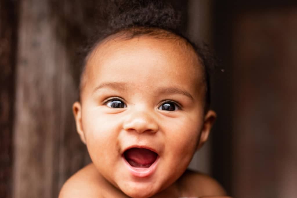 Baby Aysllan smiling in the doorway of his home in Brazil