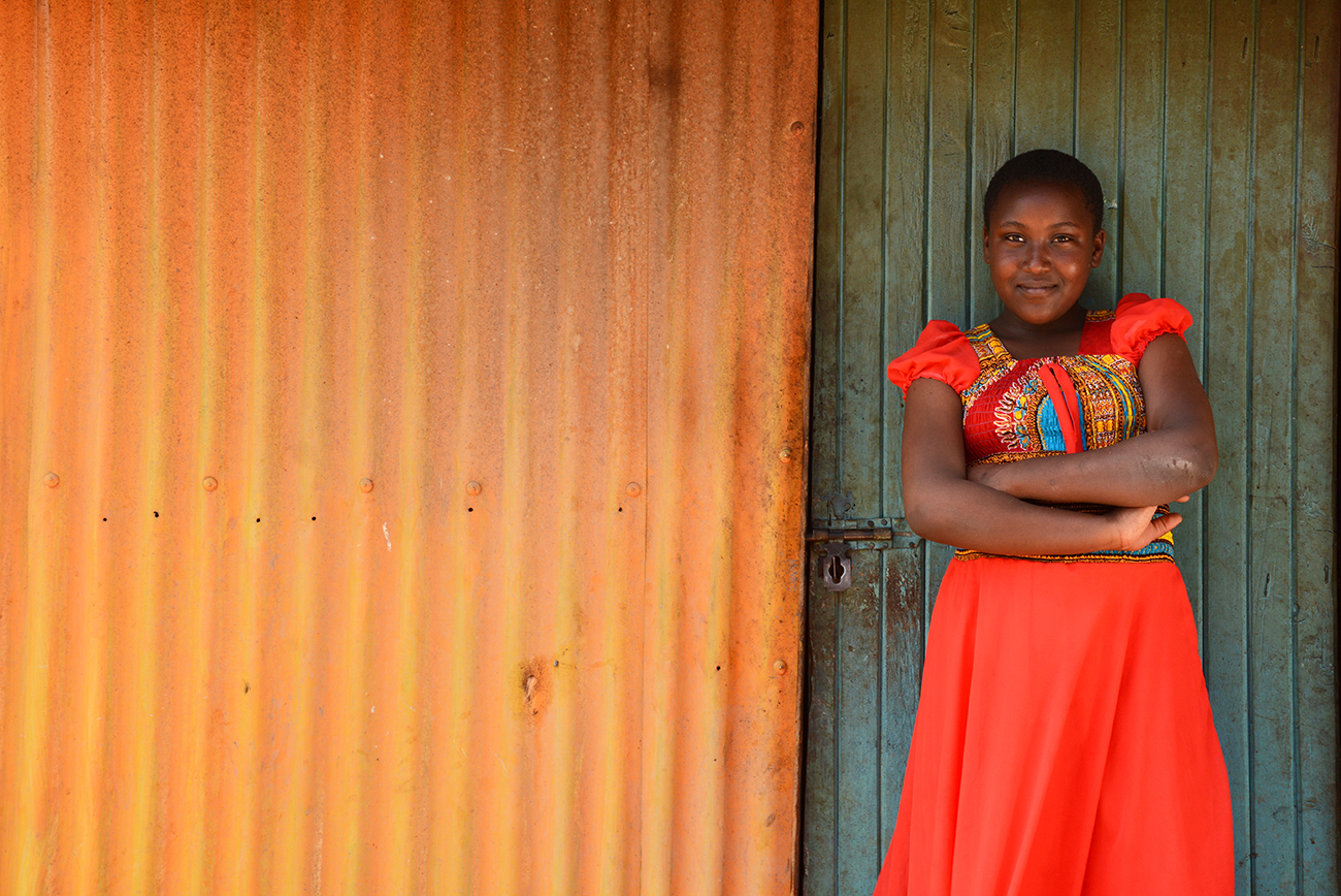 A girl in Kenya standing against a wall