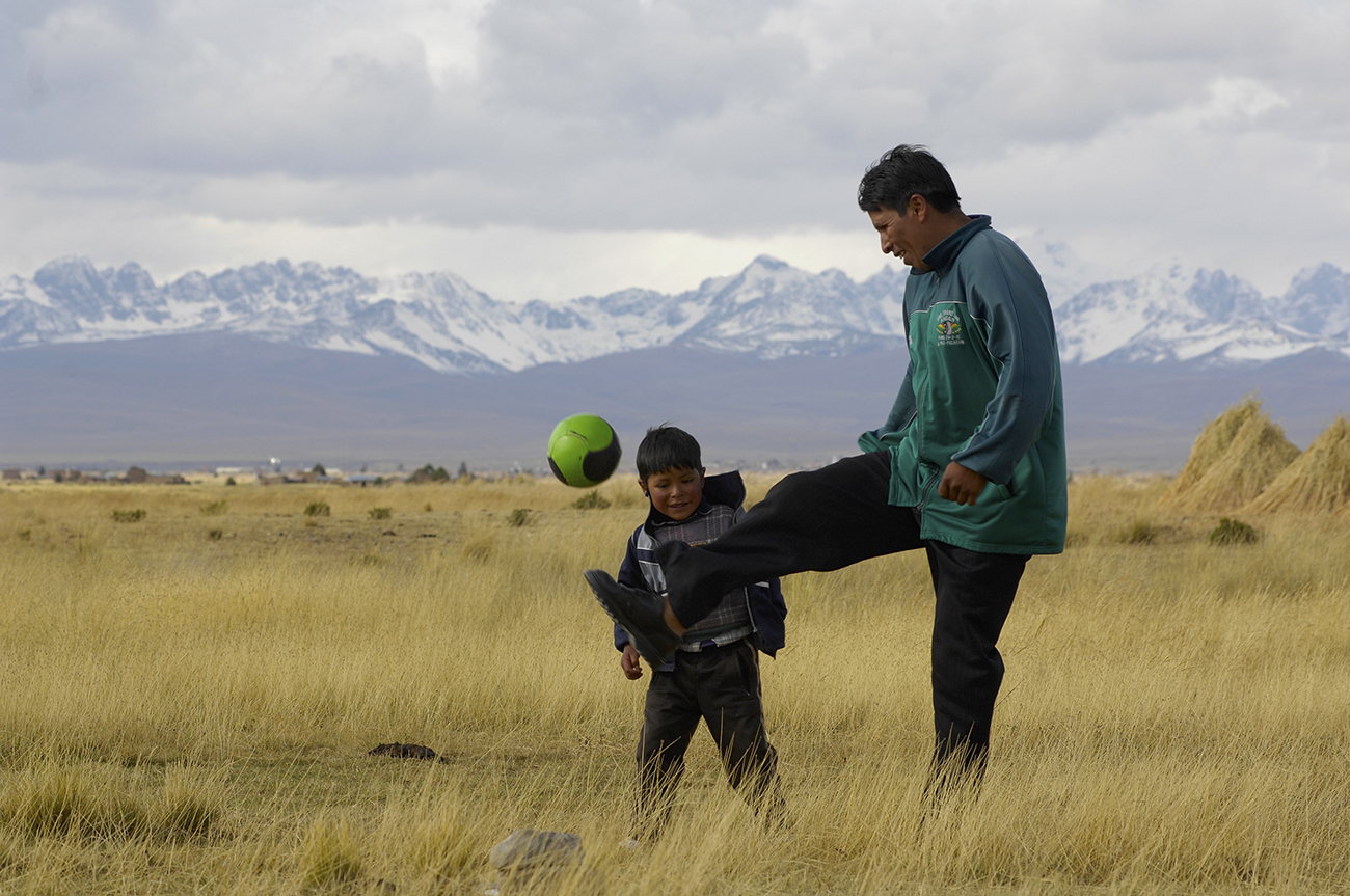 father and son playing football