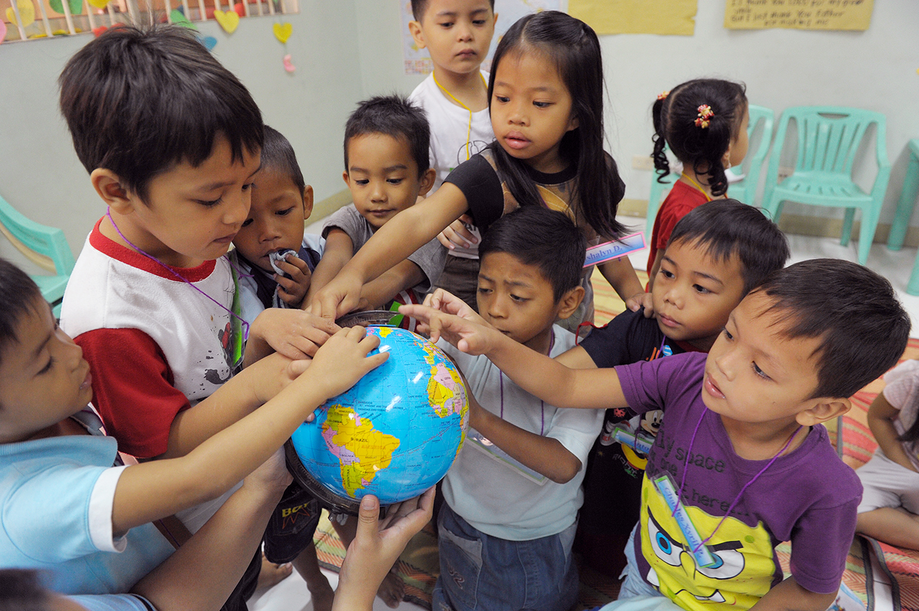 classroom group of children with globe of world