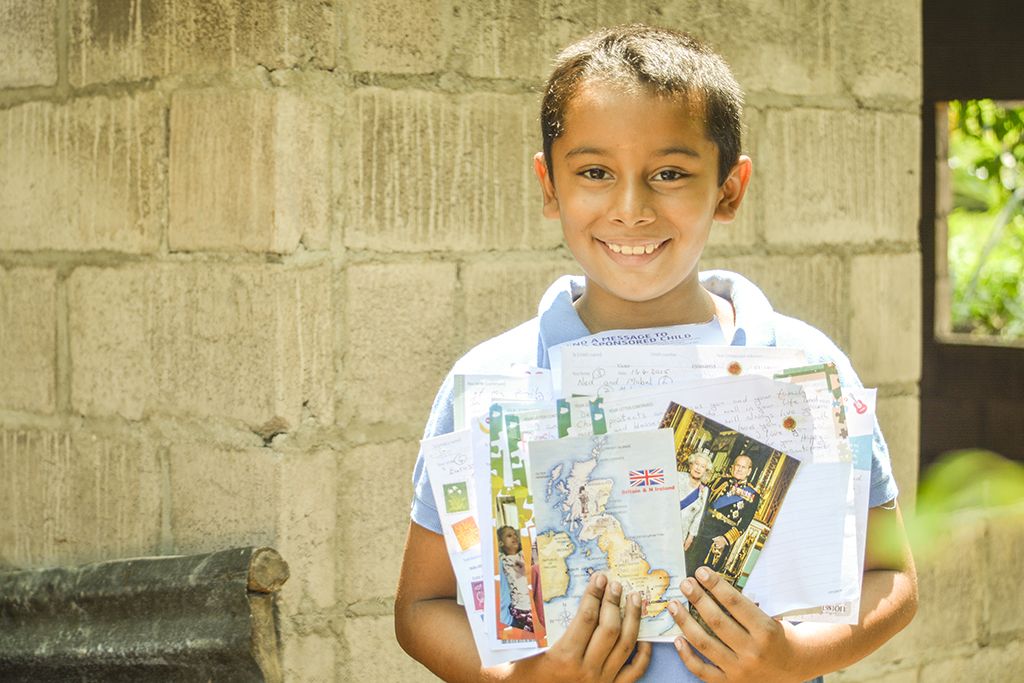boy holding letters from sponsor