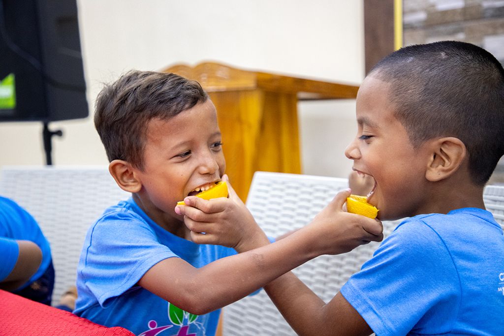 Boys eating oranges