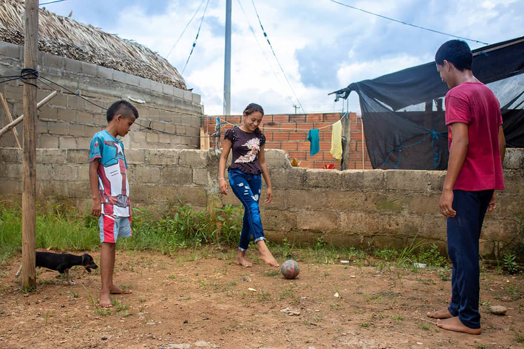 Dayana playing football with her brothers