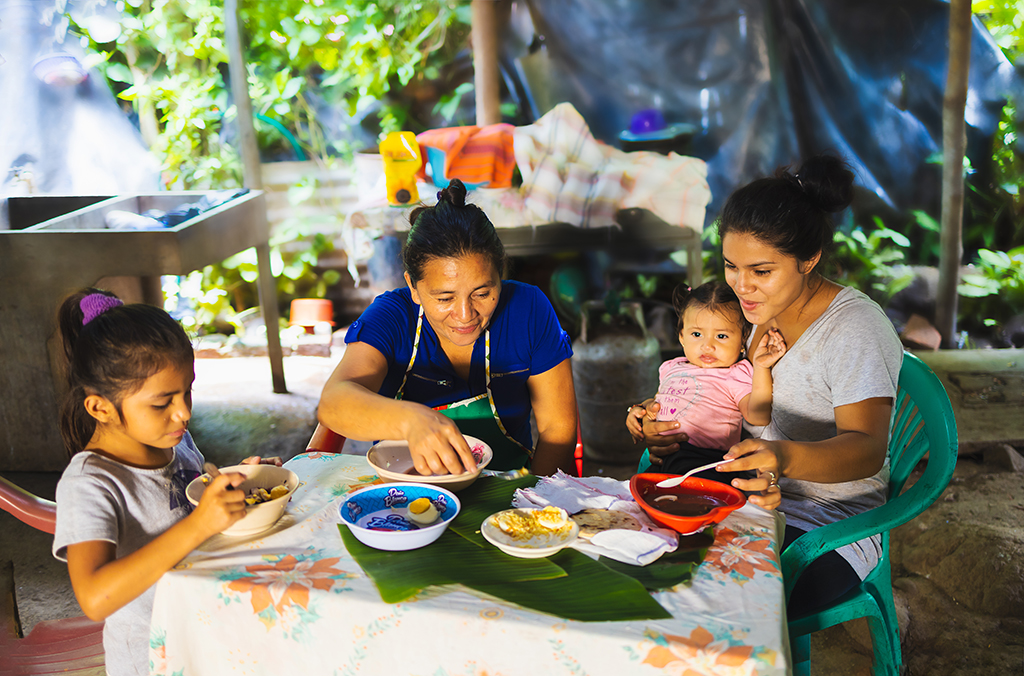 A family in El Salvador sharing a meal together thanks to a food parcel they received 