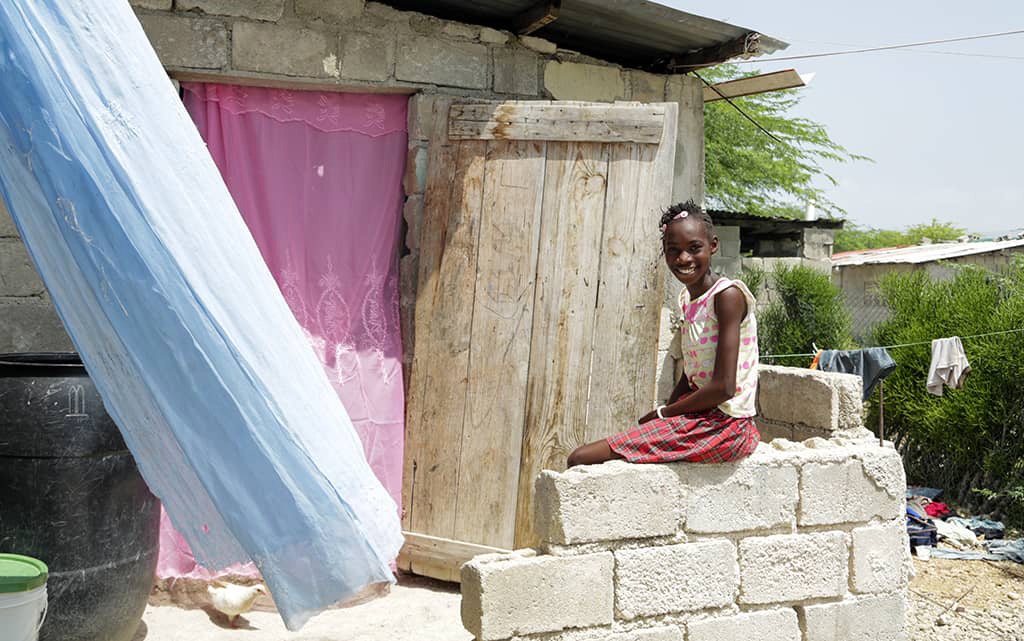 Shamaika outside her house in Haiti
