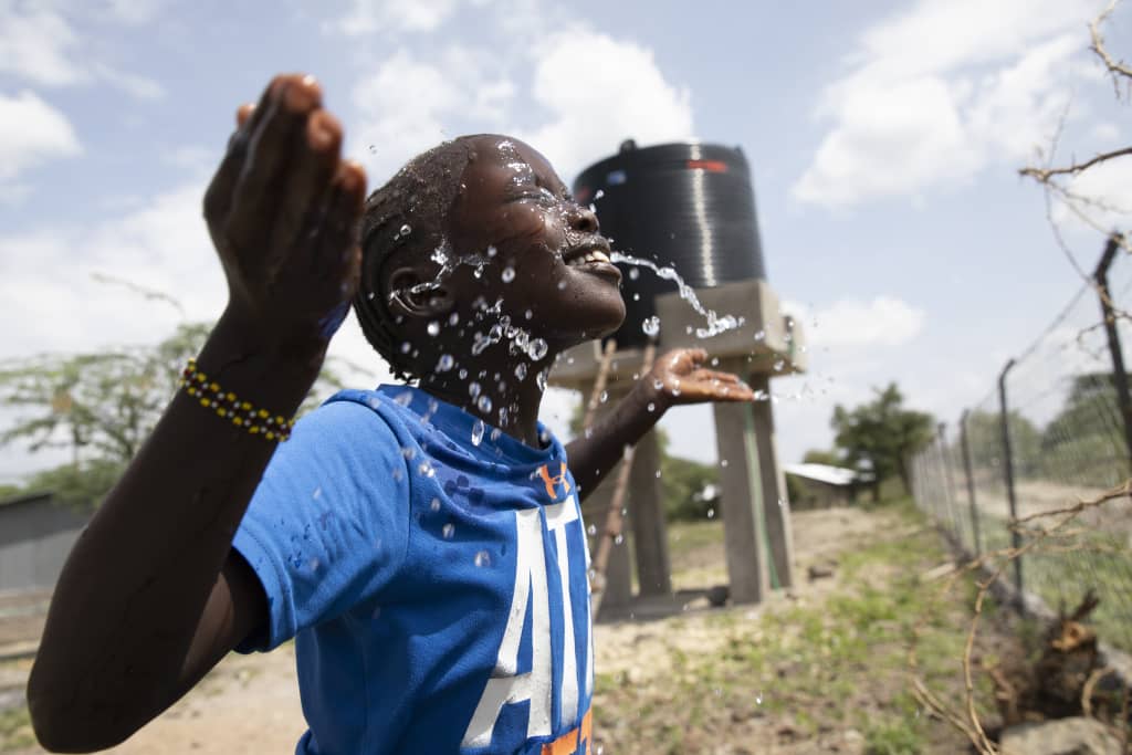 Rehema splashes clean water on her face