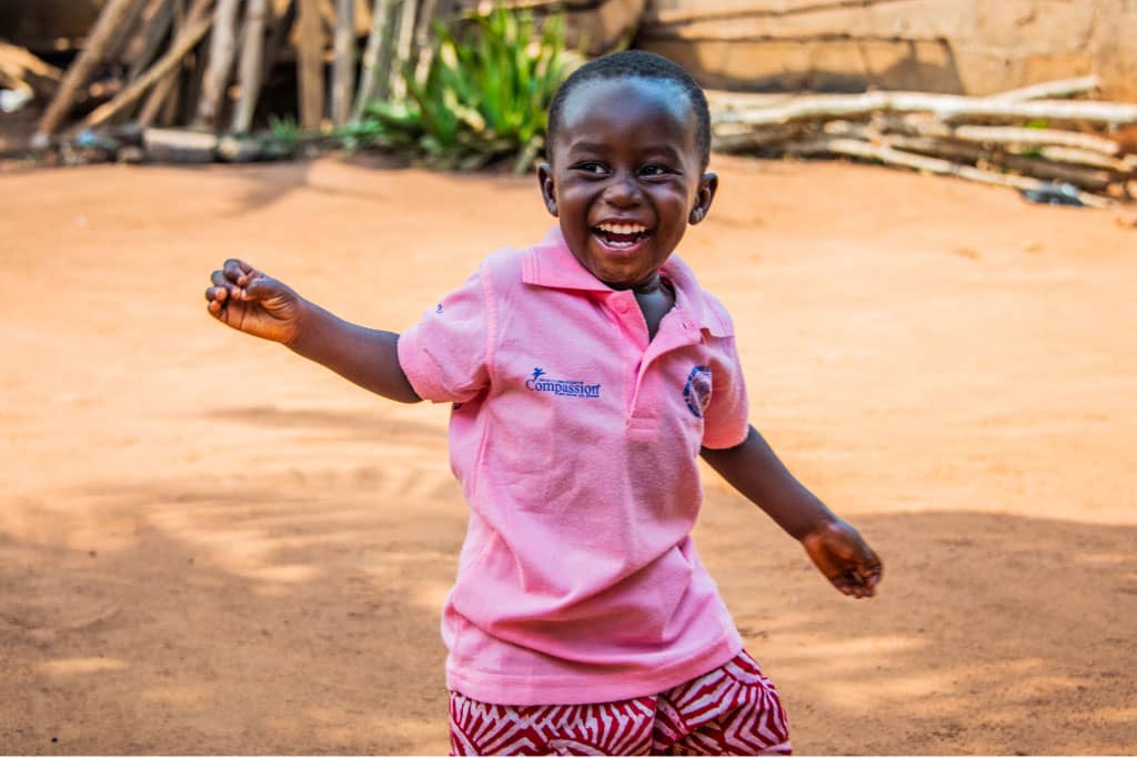 A boy laughs and runs in Togo
