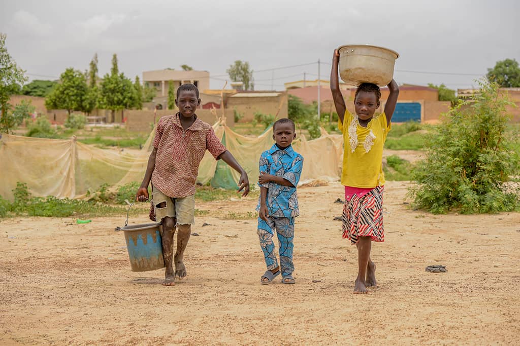 Three children carrying water