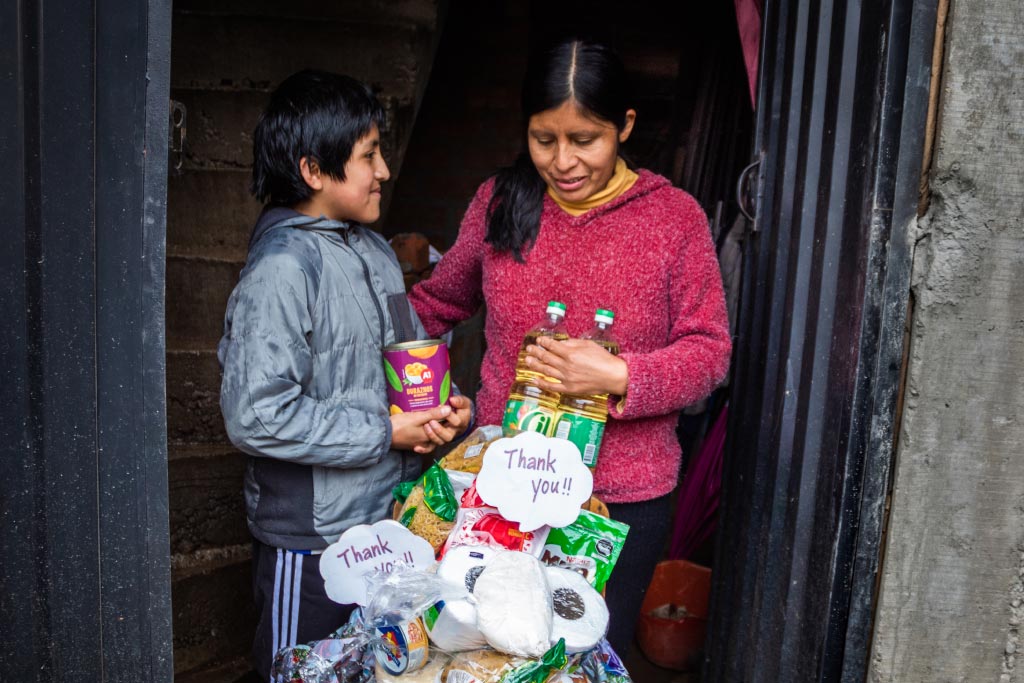 A mother and son from Peru receive a food basket