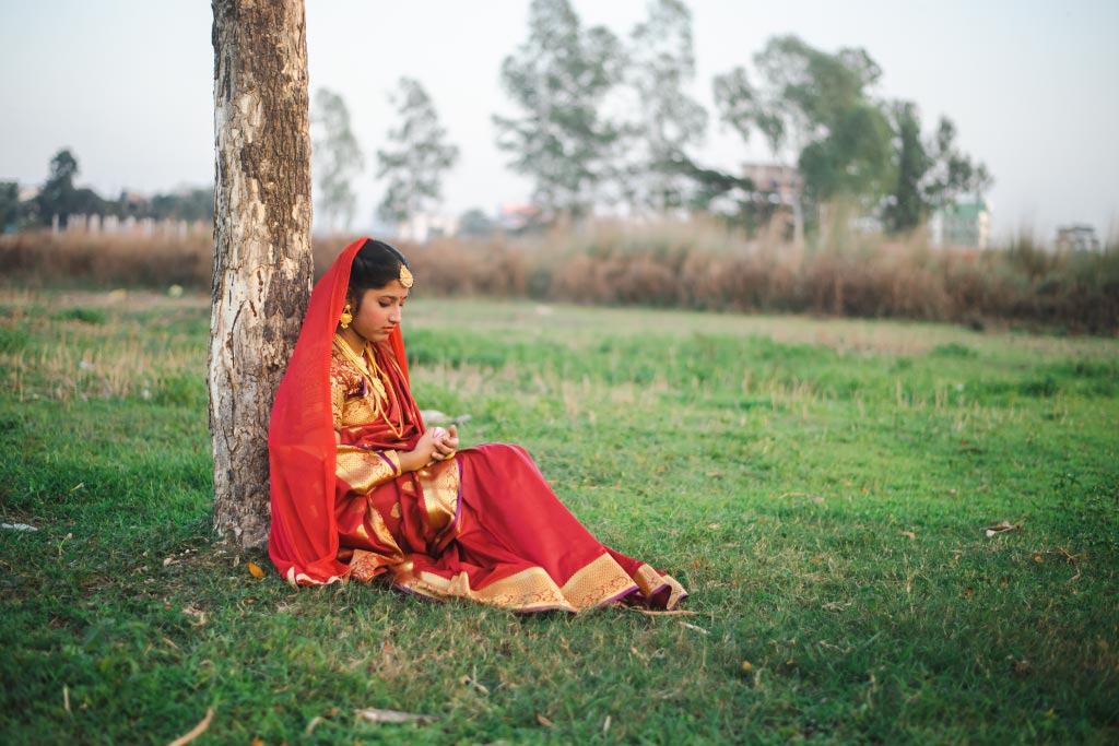 Tisha sits in bridal wear, she’s raising her voice to end child marriage.
