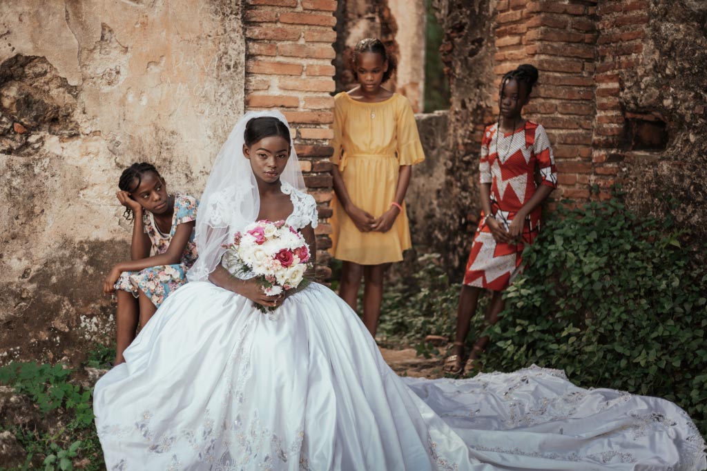 Lauri in a bridal gown, surrounded by three friends.