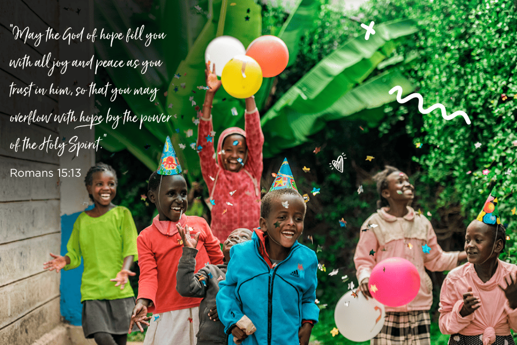 A group of Kenyan children are jumping and throwing confetti into the air.