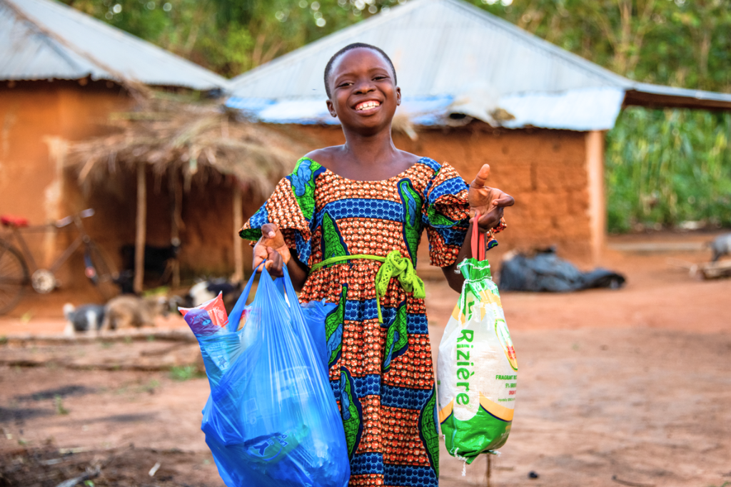 A Togolese child with bags of food