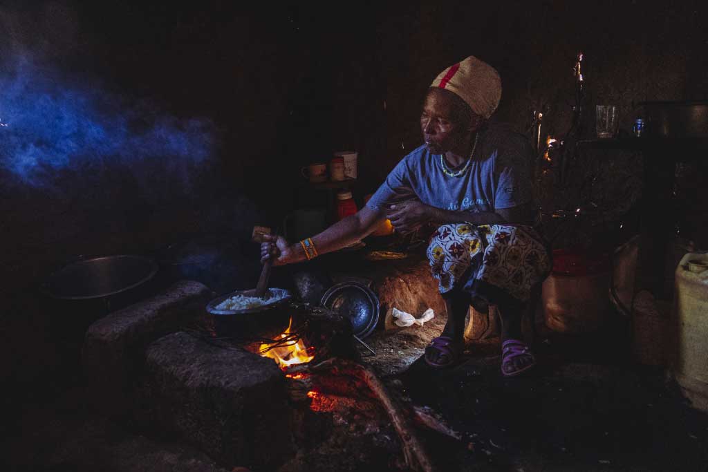 Eunice, Kenya cooks over an open fire