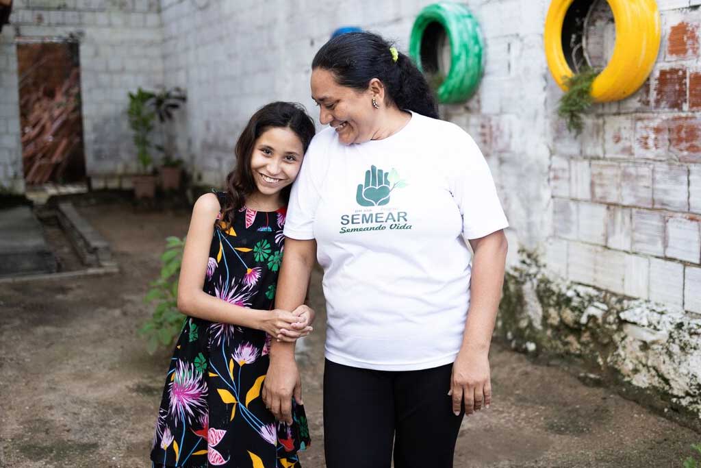 Eliane, a tutor, stands with a pupil in Brazil