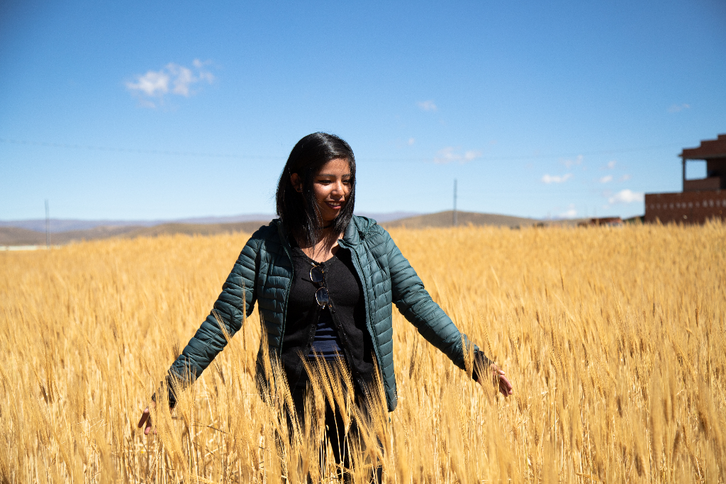 Lidia is standing in a field of tall grass.