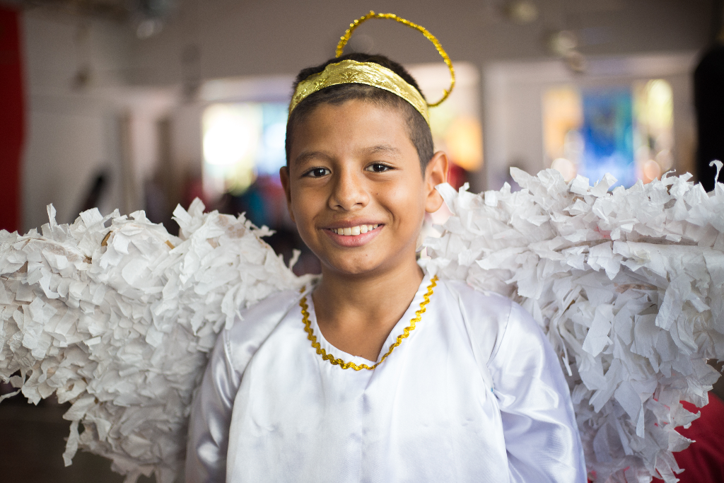 Javier in Colombia is wearing an angel costume and smiling at the camera.