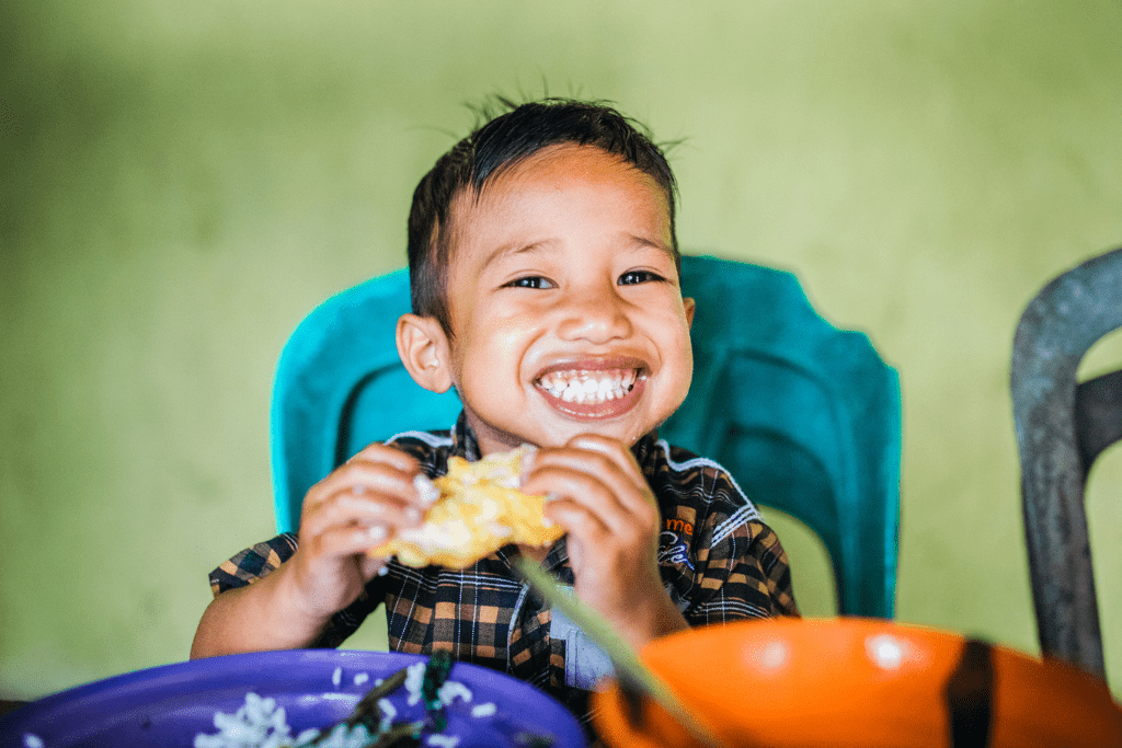 Juandin from Indonesia enjoying lunch provided by his Compassion project